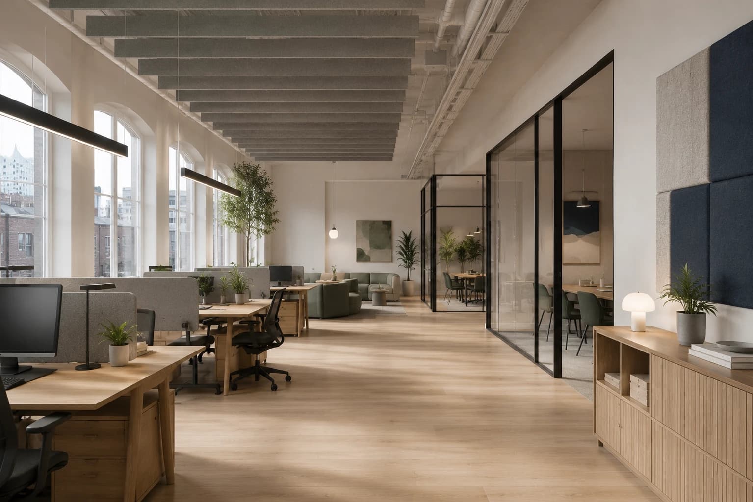 Open, light-filled office landscape in a converted industrial loft with arched windows and oak furniture